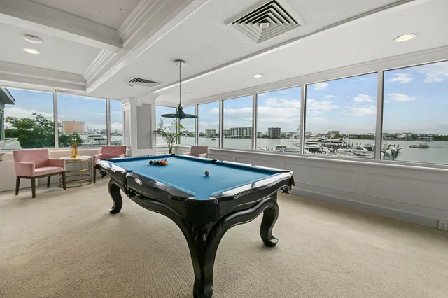 a room with pool table and windows