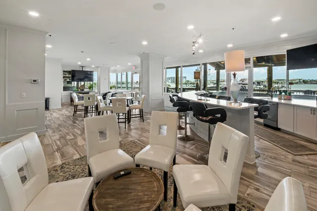a living room with furniture kitchen area and a large window