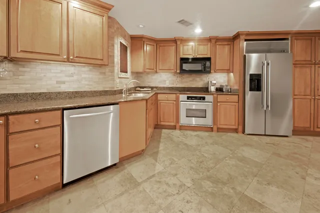 a kitchen with stainless steel appliances granite countertop a refrigerator sink and cabinets