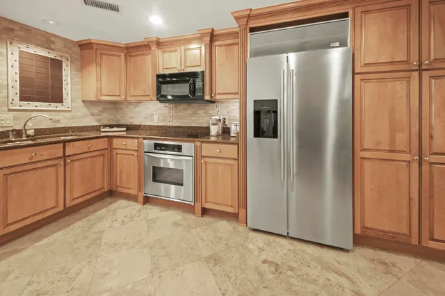 a kitchen with stainless steel appliances granite countertop a refrigerator a stove a sink and a granite counter tops
