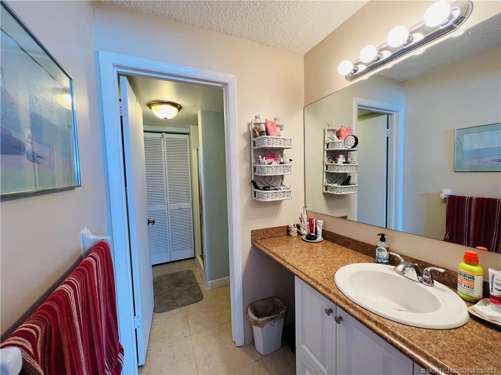 7430 South Ocean Drive, Unit 619B Jensen Beach, FL 34957 - Photo 32 of 57 a en suite bathroom with a granite countertop sink and a mirror