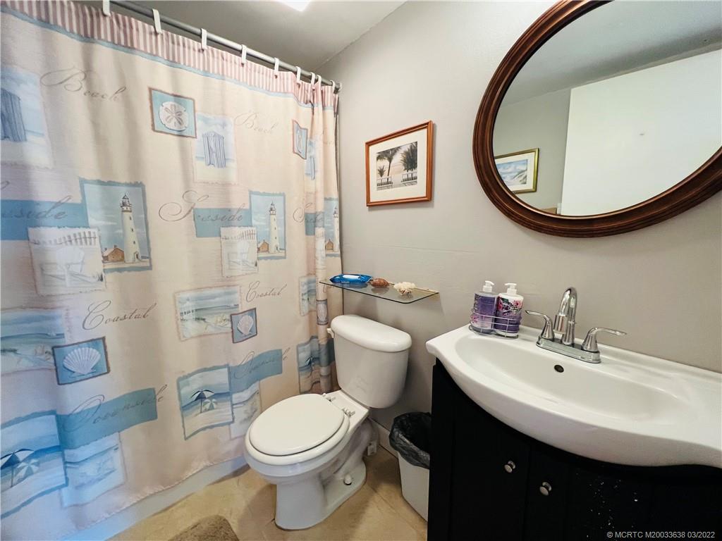7430 South Ocean Drive, Unit 619B Jensen Beach, FL 34957 - Photo 42 of 57 a bathroom with a sink a mirror a toilet and a shower