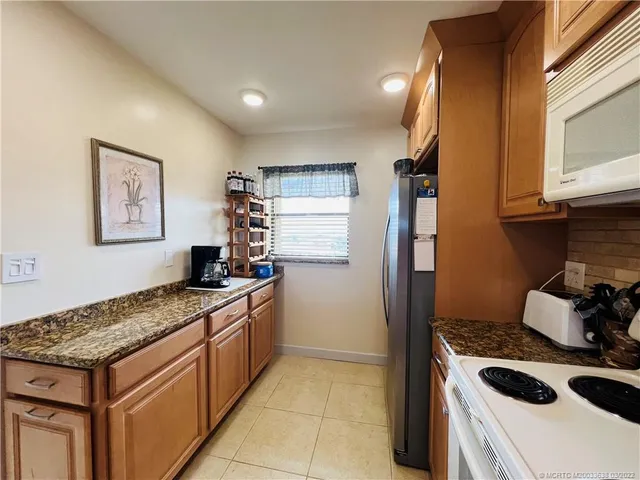 a kitchen with stainless steel appliances granite countertop a stove a refrigerator and a microwave