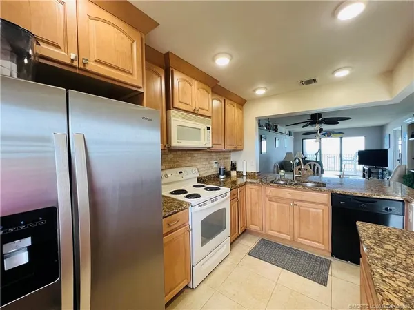 a kitchen with stainless steel appliances granite countertop a stove a refrigerator and a microwave