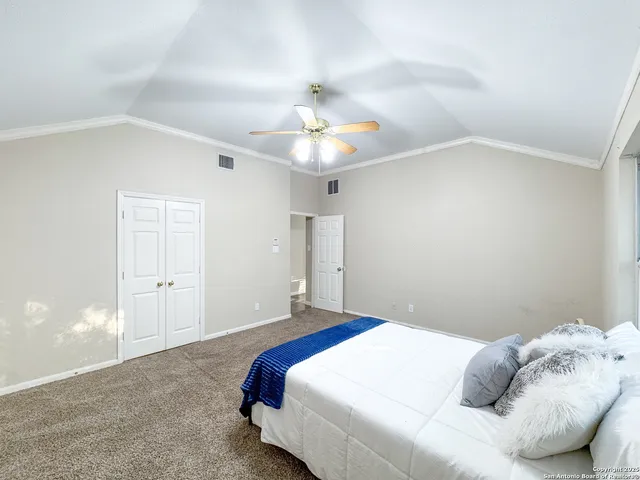 a bedroom with a bed and a chandelier fan