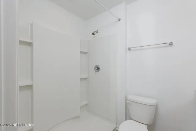 a view of a hallway with wooden floor and closet