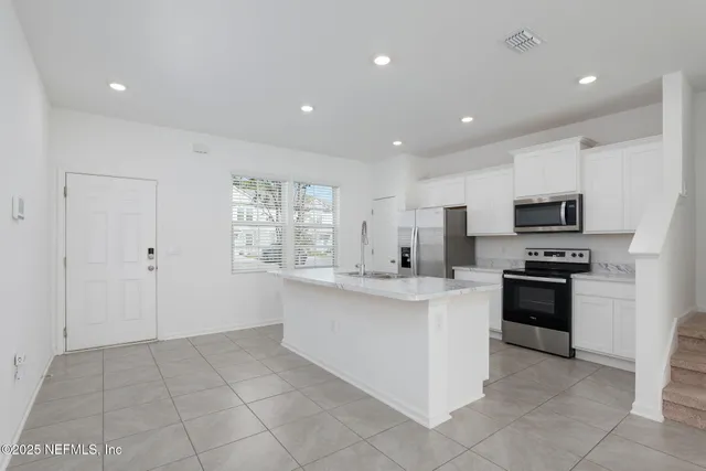 a kitchen with stainless steel appliances a stove microwave and sink