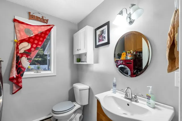 a bathroom with a toilet a sink and mirror