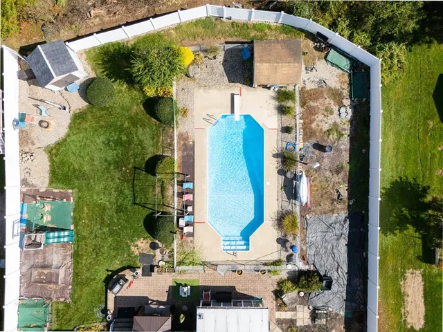 an aerial view of a residential houses with yard