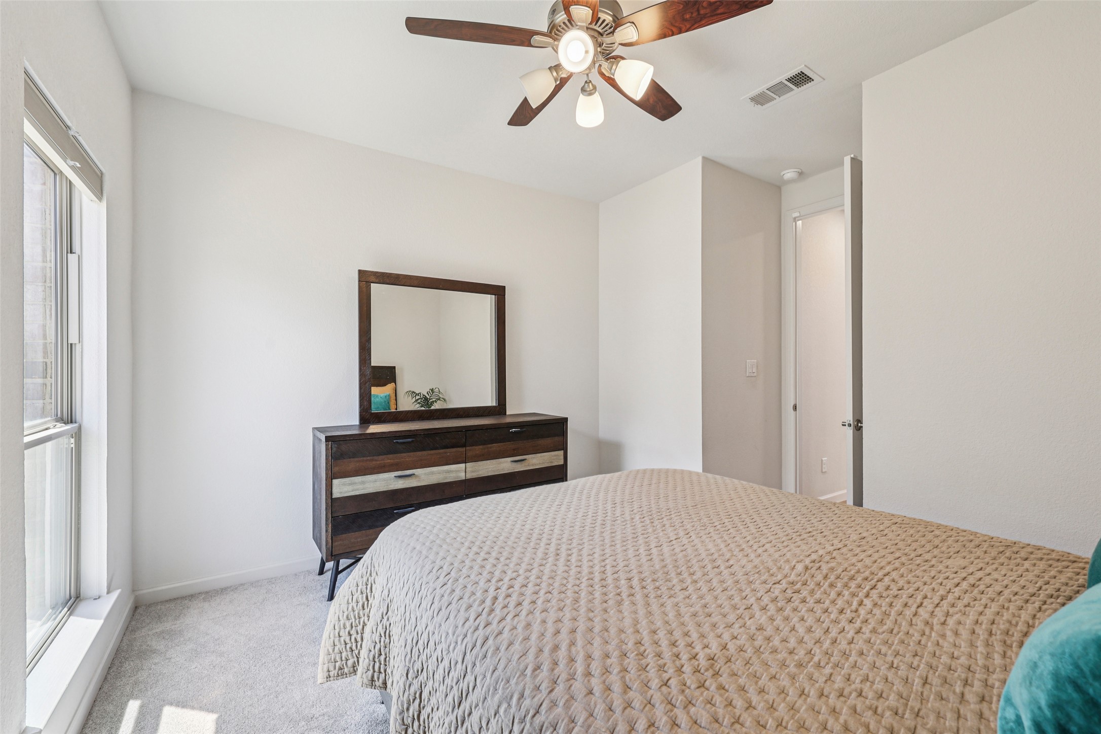 1140 Bryson Rdg Trail Leander, TX 78641 - Photo 21 of 39 This room features a window providing natural light, a ceiling fan with integrated lighting, and light-colored carpeting