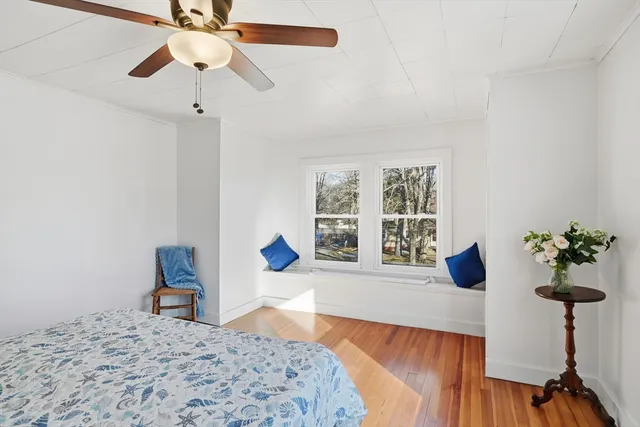 a bedroom with a bed chandelier and a window
