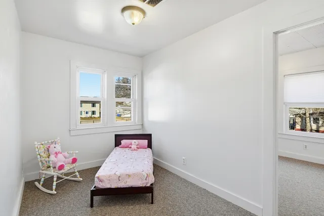 a room with a baby bed furniture and a window