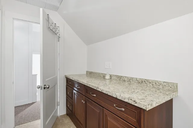 a utility room with granite countertop cabinets and utility view