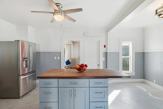 a kitchen with stainless steel appliances kitchen island granite countertop a refrigerator and a sink
