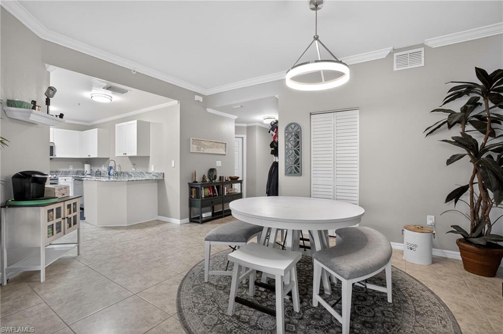 519 Roma Court, Unit 3101 Naples, FL 34110 - Photo 13 of 30 a kitchen with stainless steel appliances granite countertop a dining table chairs and white cabinets