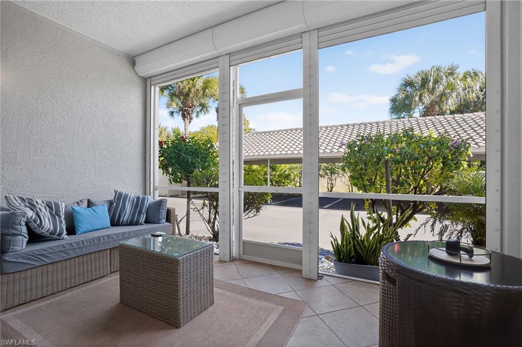 519 Roma Court, Unit 3101 Naples, FL 34110 - Photo 28 of 30 a living room with couch and a floor to ceiling window