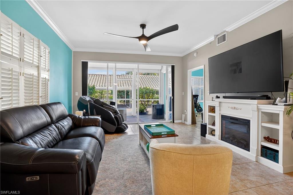 519 Roma Court, Unit 3101 Naples, FL 34110 - Photo 6 of 30 a living room with furniture a fireplace and a flat screen tv