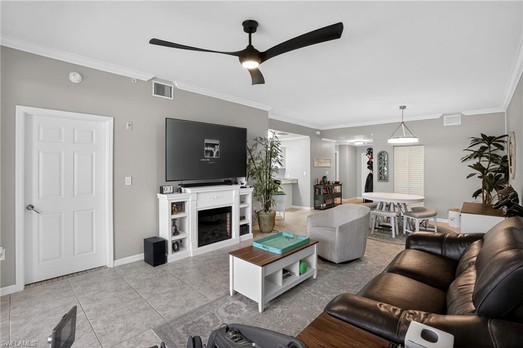 519 Roma Court, Unit 3101 Naples, FL 34110 - Photo 8 of 30 a living room with furniture a flat screen tv and a fireplace