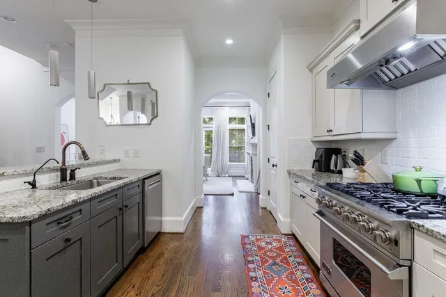 a kitchen with stainless steel appliances granite countertop a sink a stove and cabinets
