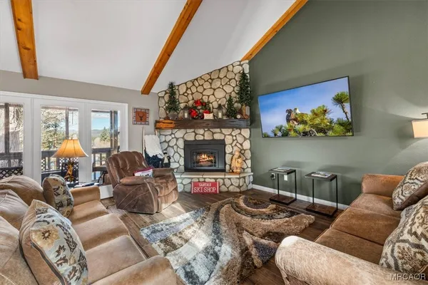 a kitchen with stainless steel appliances granite countertop a refrigerator a sink and white cabinets next to a window