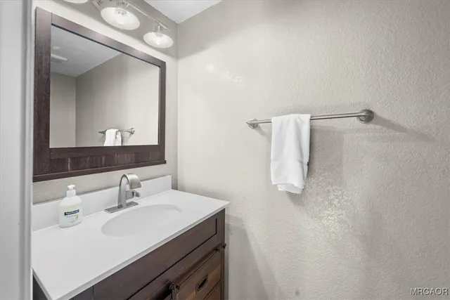 a bathroom with a sink a toilet and a mirror