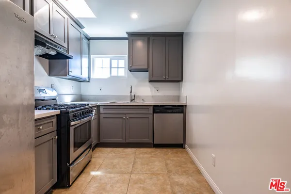 a kitchen with stainless steel appliances granite countertop a refrigerator and a stove