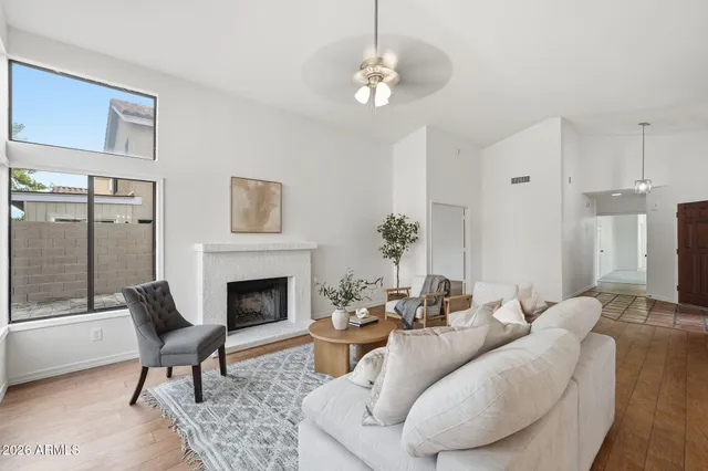 a living room with furniture a fireplace and a chandelier