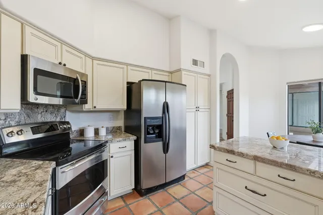 a kitchen with stainless steel appliances granite countertop a refrigerator stove microwave and sink