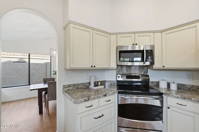 a kitchen with stainless steel appliances granite countertop a stove a microwave and a refrigerator