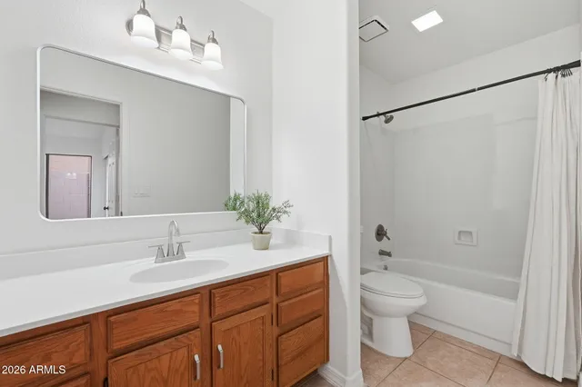 a bathroom with a granite countertop sink a toilet and shower