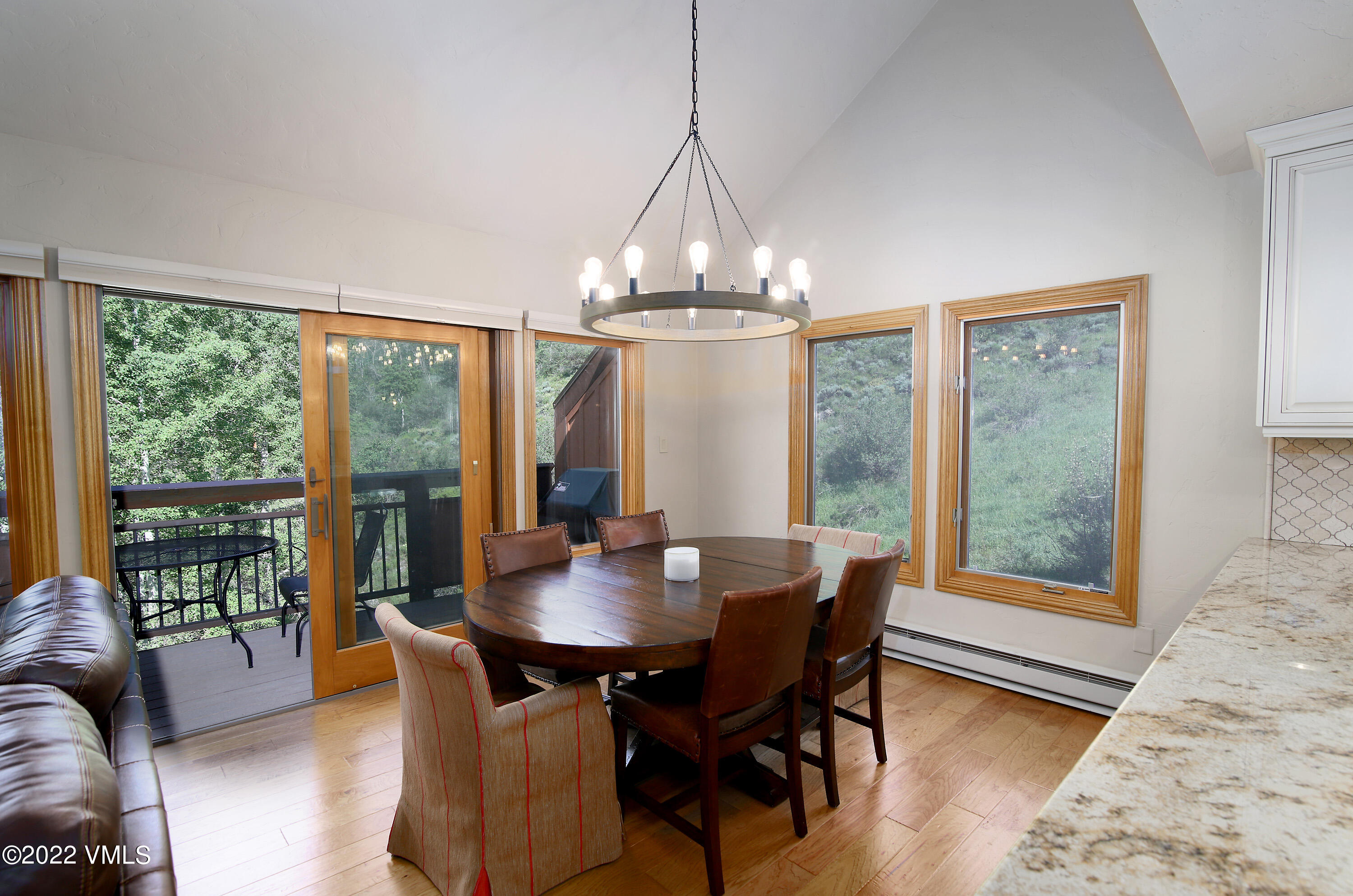 2875 Manns Ranch Road, Unit H3 Vail, CO 81657 - Photo 6 of 18 a dining room with wooden floor a chandelier a glass table and chairs