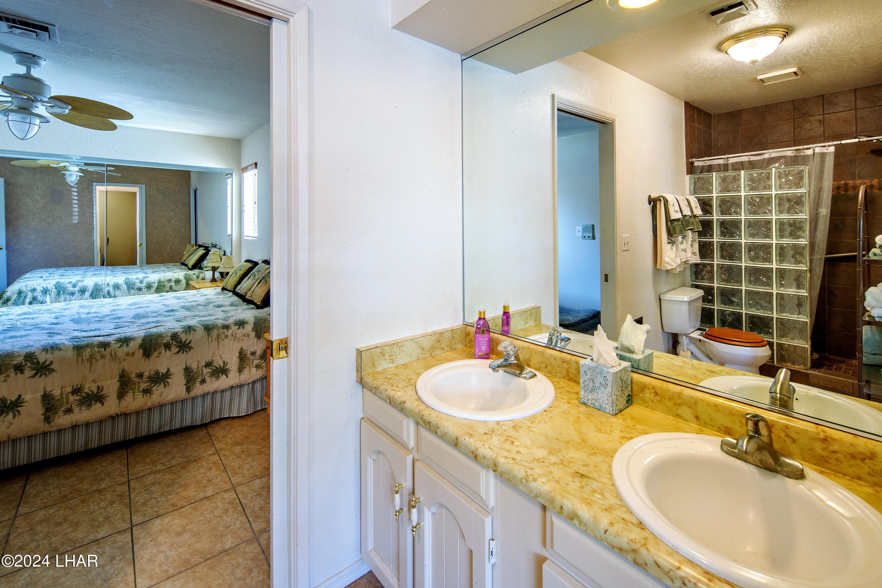 8702 Papago Loop Parker, AZ 85344 - Photo 31 of 36 a bathroom with a granite countertop sink and a mirror