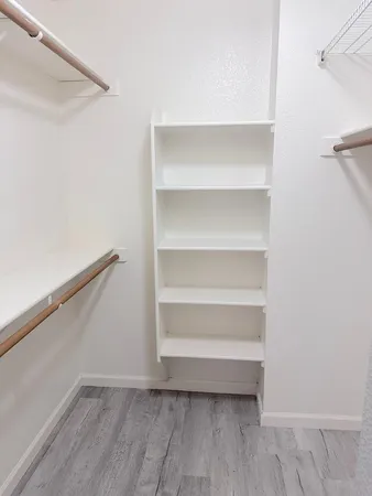 a view of walk in closet with empty racks