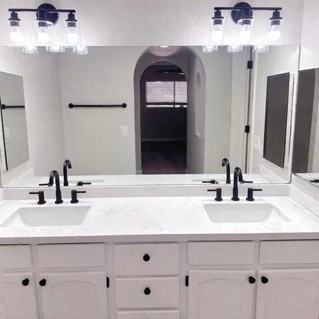 a bathroom with double vanity sink and two mirror
