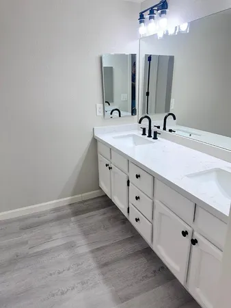 a bathroom with a double vanity sink and mirror