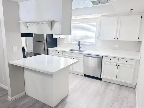 a kitchen with cabinets and white stainless steel appliances