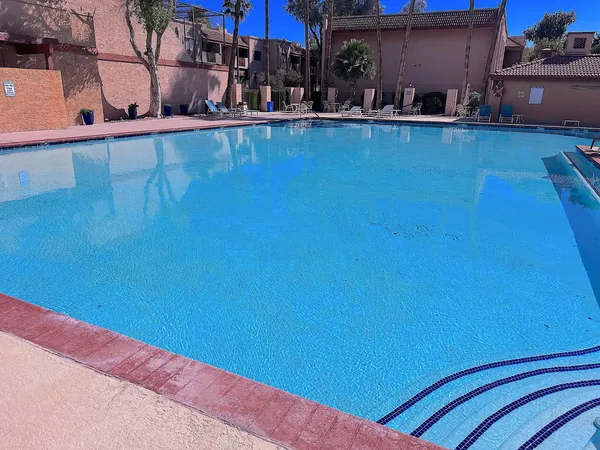 a view of a swimming pool with lawn chairs