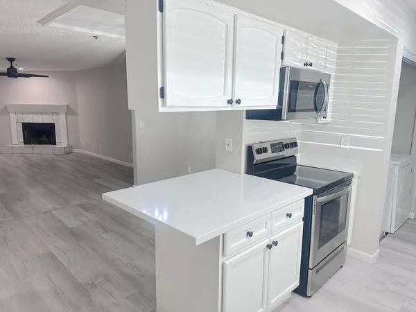 a kitchen with white cabinets and white appliances
