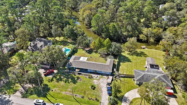 an aerial view of residential houses with outdoor space and trees all around