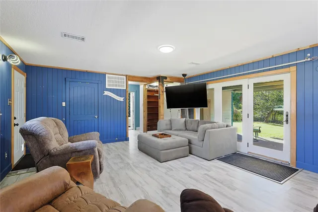 a kitchen with stainless steel appliances granite countertop a refrigerator a sink a stove and white cabinets with wooden floor