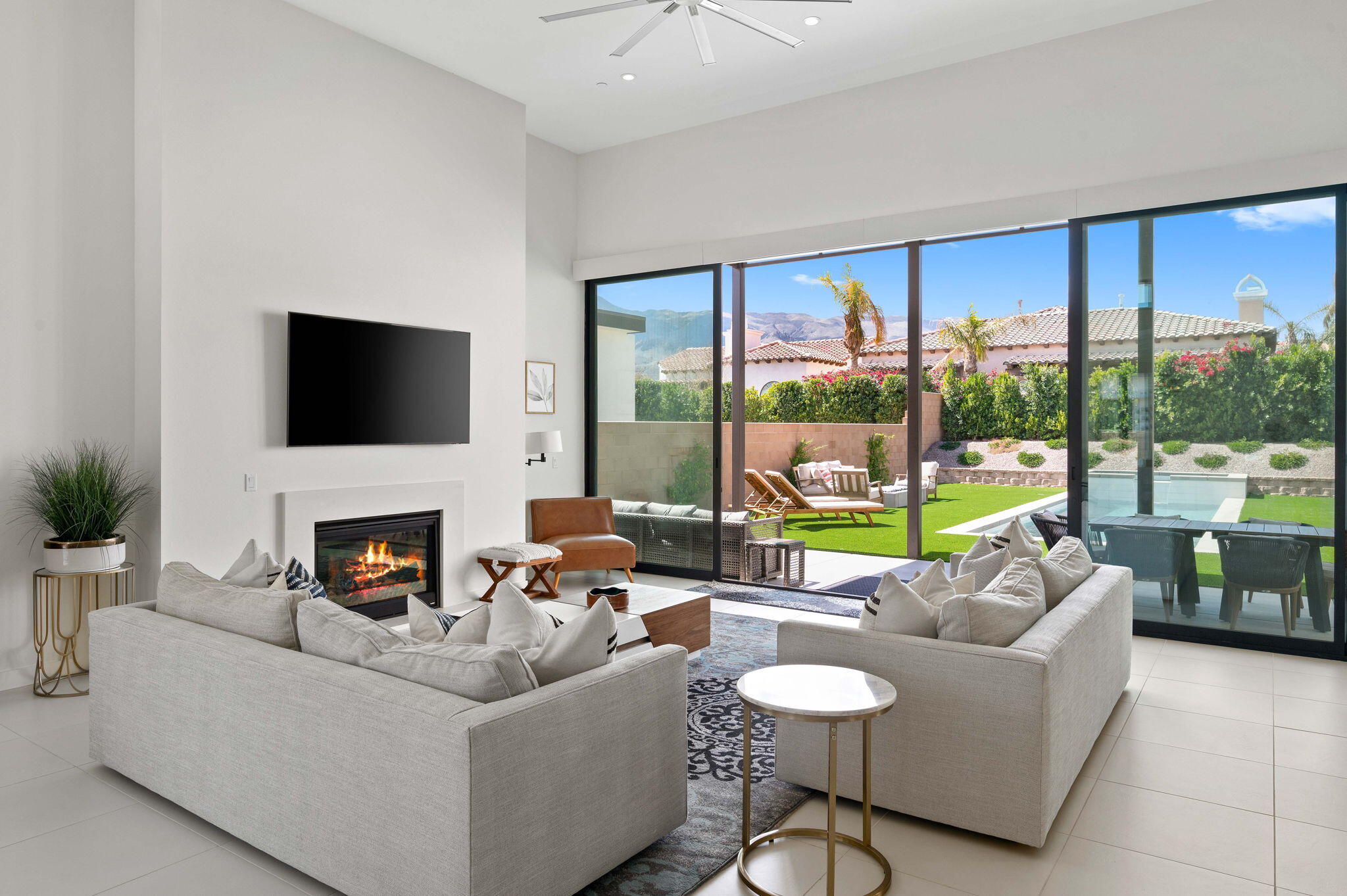 57627 Santo Thomas La Quinta, CA 92253 - Photo 12 of 37 a living room with furniture a fireplace and a large window with garden view