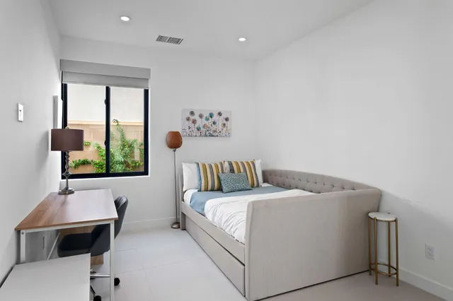 a bed sitting in a bedroom next to a window