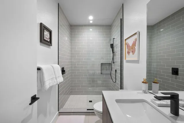 a bathroom with a sink a toilet and shower