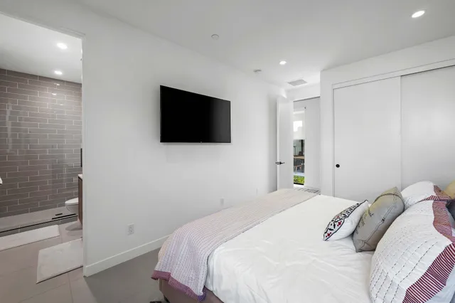 a bedroom with a bed and a flat screen tv