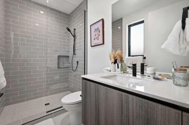 a bathroom with a granite countertop toilet sink and mirror