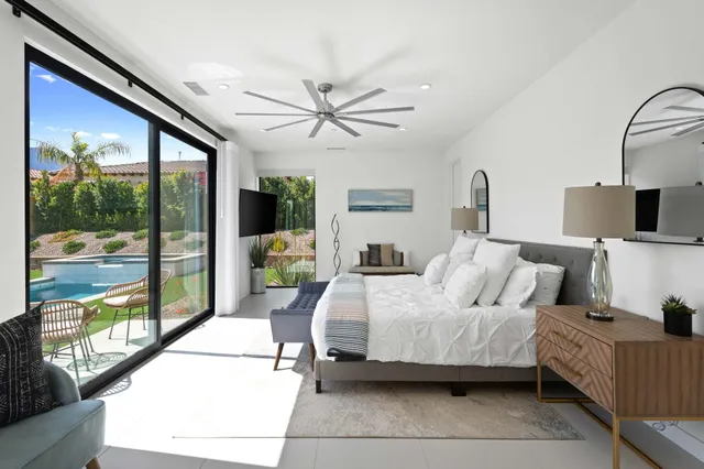 a bedroom with a balcony a bed and a large window