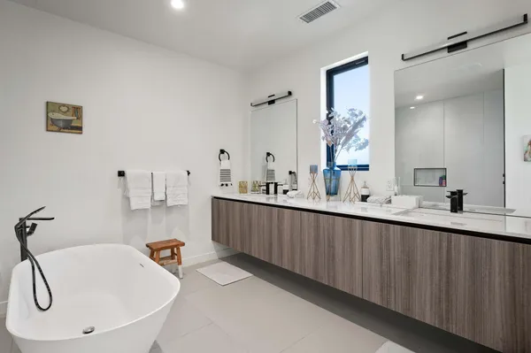 a bathroom with a tub sink and mirror