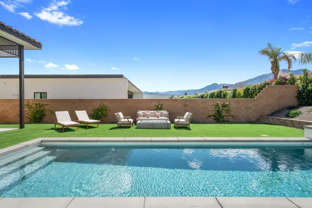 a front view of a house with a yard and outdoor seating