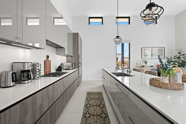 a large kitchen with kitchen island a large counter space a sink and appliances