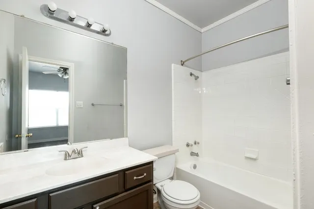 a bathroom with a sink a toilet a mirror and shower
